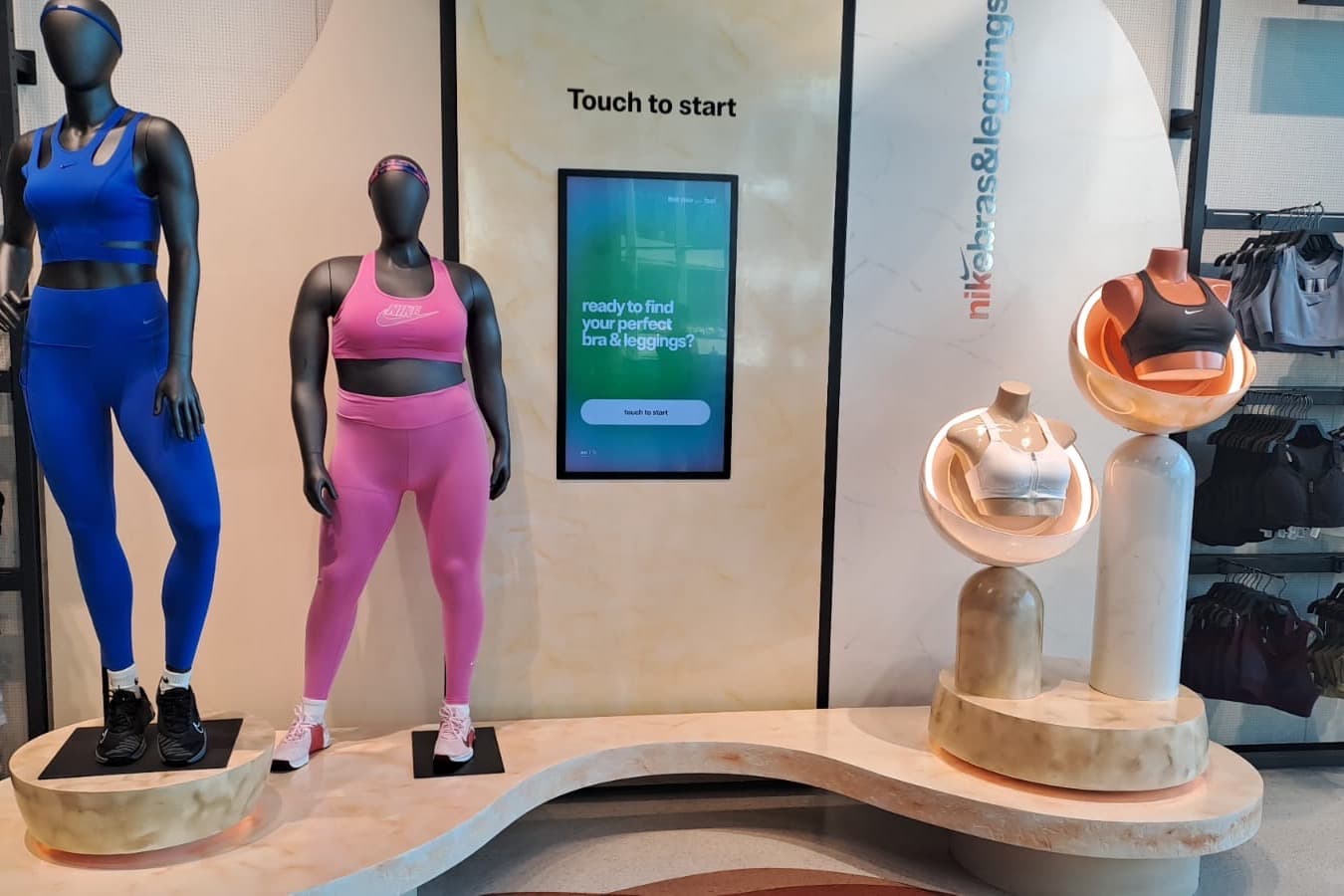 Curved timber retail podium with mannequins and illuminated product plinths