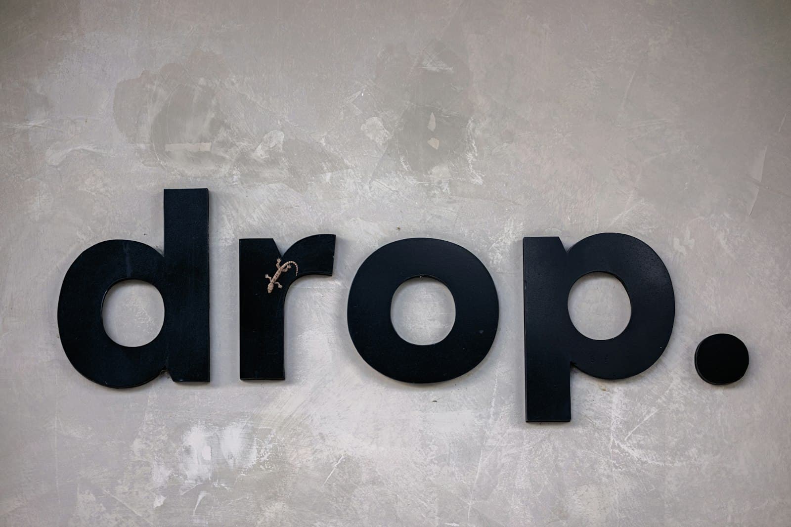Black dimensional letters mounted on a polished concrete wall